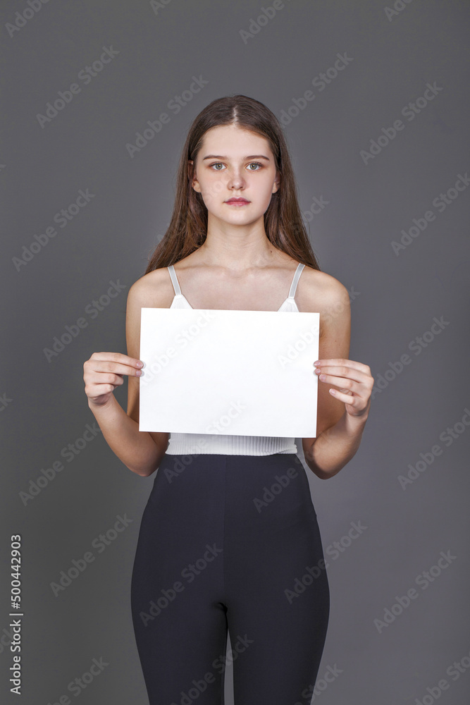young girl with a blank sheet of paper - place for an inscription young girl with a blank sheet of paper - place for an inscription