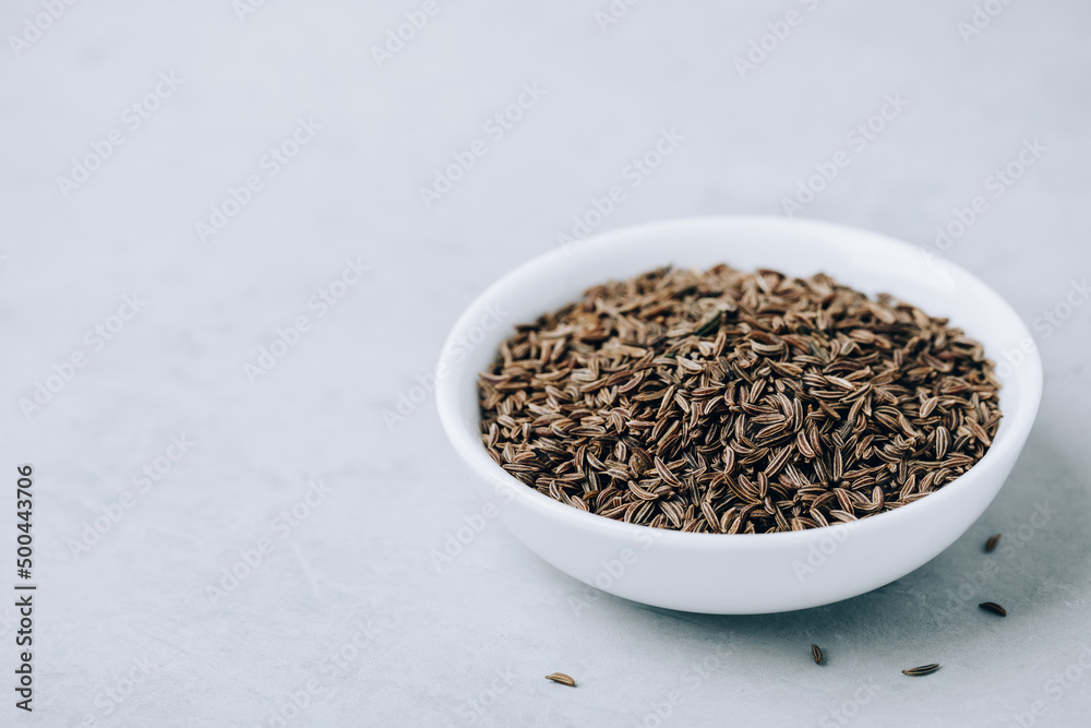 Cumin seeds or caraway in white bowl with copy space Cumin seeds or caraway in white bowl with copy space