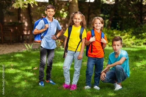 Group of happy school child with schoolbag in outdoor park