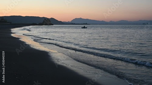 Wallpaper Mural Dawn on the Tyrrhenian Sea. Calm sea, waves beat against the shore, a man in a boat floats along the shore. morning meditation Torontodigital.ca