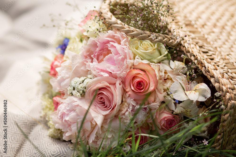 Delicate bouquet in a straw basket. A basket on a blanket outside. Wedding bouquet. Delicate bouquet in a straw basket. A basket on a blanket outside. Wedding bouquet.