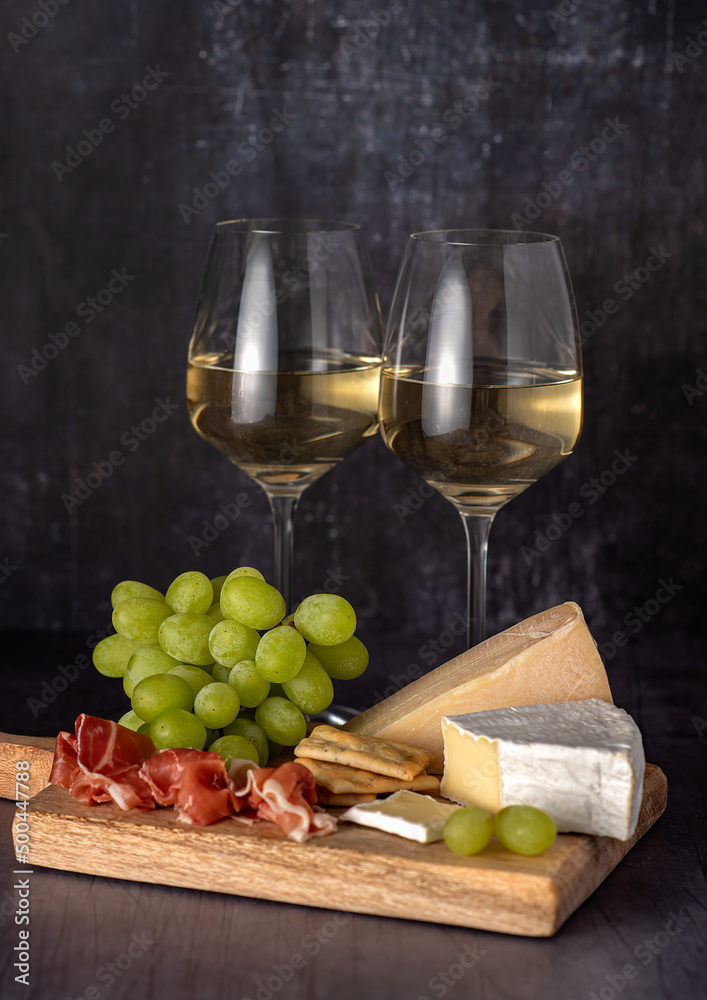 Food photography of white wine, cheese, grape, prosciutto