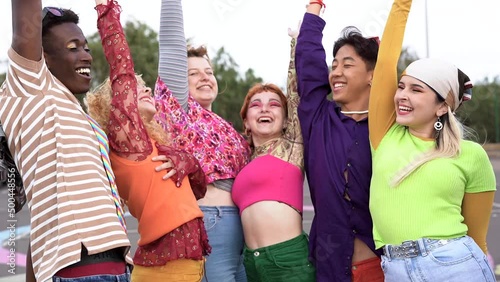 Happy young diverse people celebrating and stacking hands outdoor	