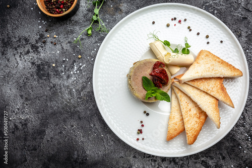 Delicious chicken liver pate with butter and sun-dried tomatoes and bread on plate. Healthy food trend