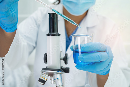 Asian scientist biochemist or microbiologist working research with a microscope in laboratory. For protect outbreak Coronavirus Covid19, bacteria and germs.