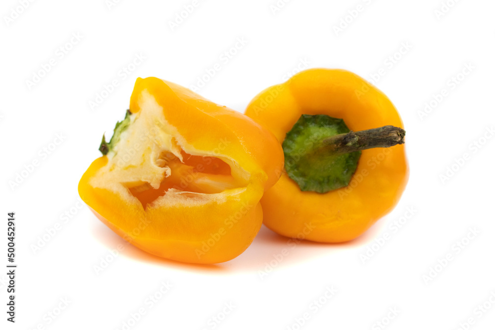 One whole yellow pepper and one cut in half. Isolated on white background. Capsicum baccatum is a species of the Solanaceae genus Capsicum.