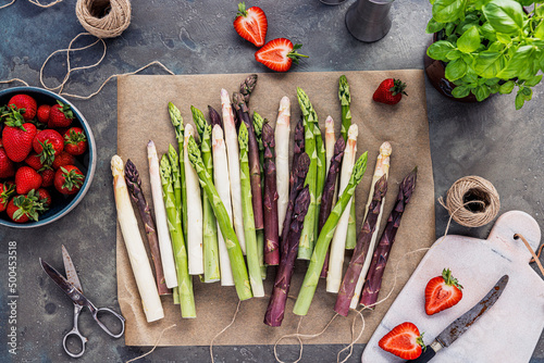 Green, white and purple asparagus on a kitchen background