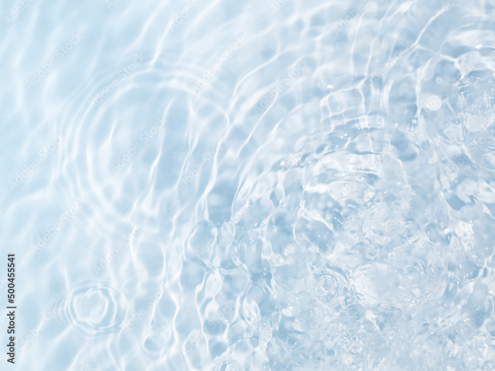 Blue water background with drop circles, splashes and ripples on the surface. Creative background design