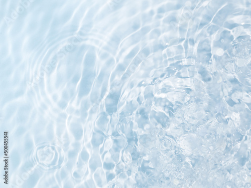 Blue water background with drop circles, splashes and ripples on the surface. Creative background design