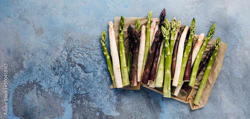 Green, white and purple asparagus on a kitchen background