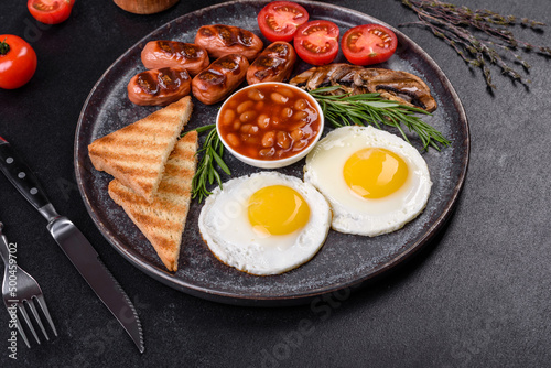 Full english breakfast with bean, fried eggs, roasted sausages, tomatoes and mushrooms