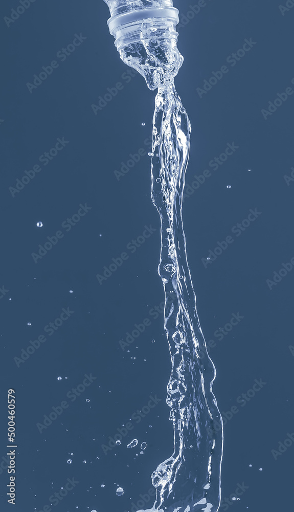 Splash of water from a bottle on a blue background. Reflection on the surface of the water. Splash of water from a bottle on a blue background. Reflection on the surface of the water.