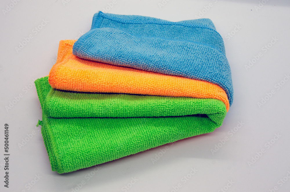 Isolated soft, fluffy, clean folded multiple colorful towel on white background, blue, orange, green fabric towel Isolated soft, fluffy, clean folded multiple colorful towel on white background, blue, orange, green fabric towel