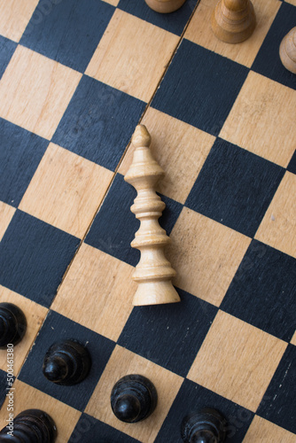 Chess board with figures. The concept of victory, the king is dead on the battlefield.