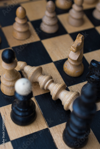 Chess board with figures. The concept of victory, the king is dead on the battlefield.