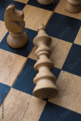 Chess board with figures. The concept of victory, the king is dead on the battlefield.
