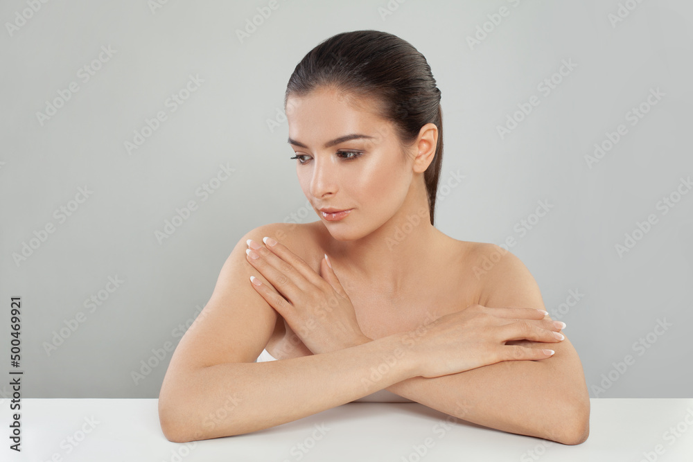 Beautiful woman with perfect skin and bare shoulders in profile on a gray background Beautiful woman with perfect skin and bare shoulders in profile on a gray background