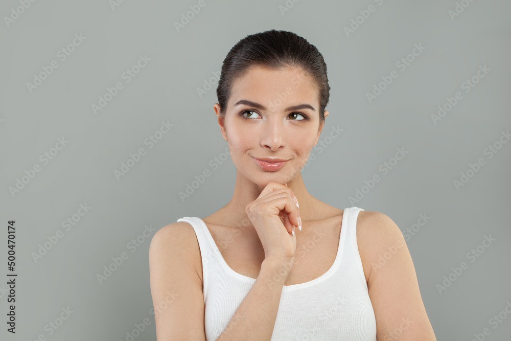 Beautiful young pretty thinking thoughtful woman posing on grey background. Beautiful young pretty thinking thoughtful woman posing on grey background.