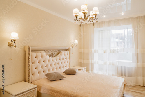 beautiful retro bedroom interior with a large classic bed with a soft headboard.