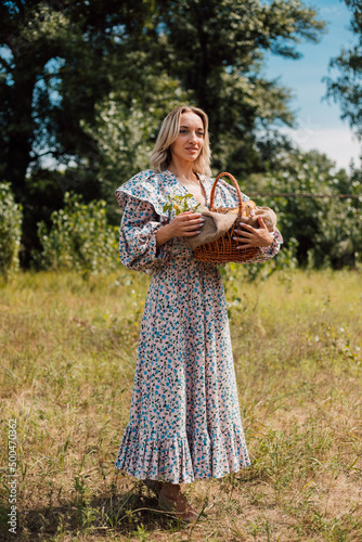 A young beautiful girl holds a basket with ducklings in her hands