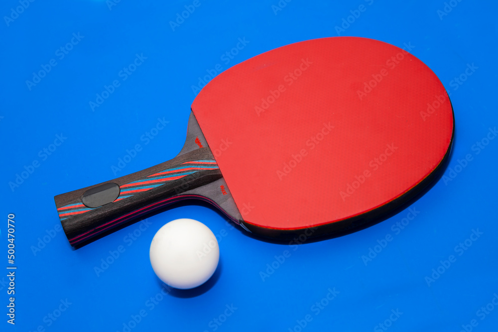 A ping pong racket on a uniform background with a table tennis ball. Free space for text. Sports equipment and ping pong game. A ping pong racket on a uniform background with a table tennis ball. Free space for text. Sports equipment and ping pong game.