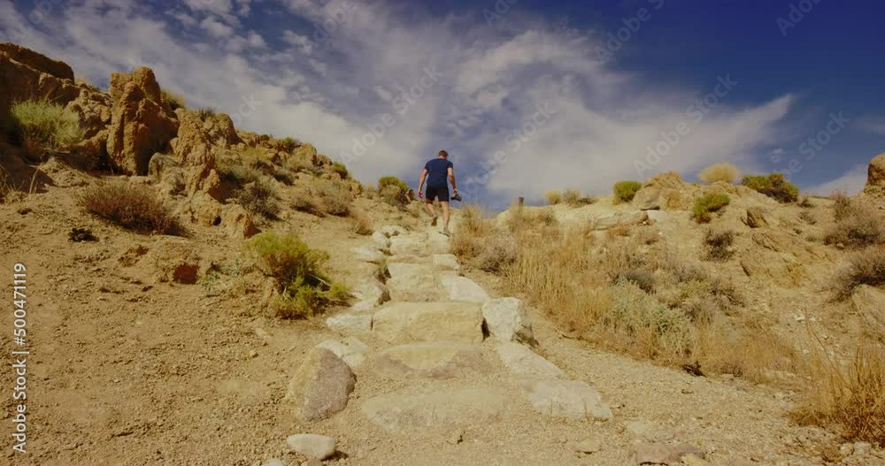 Man walking along a dirt path in the Alabama Hills, California Man walking along a dirt path in the Alabama Hills, California
