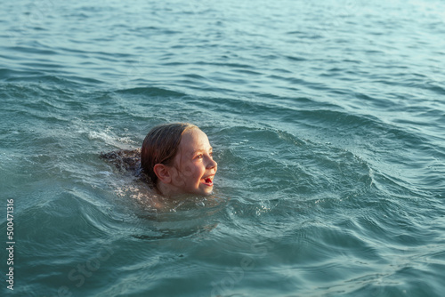 Swimming girl in blue water. Child having fun