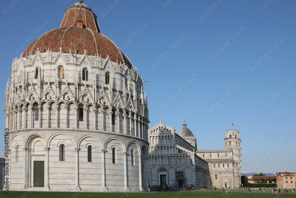 Pisa, PI, Italy - August 21, 2019:  famouse Leaning Tower and big Baptistery on the Square of Miracle  with few people