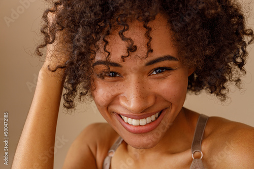 Canvastavla Happy young woman touching clean hair in studio interior