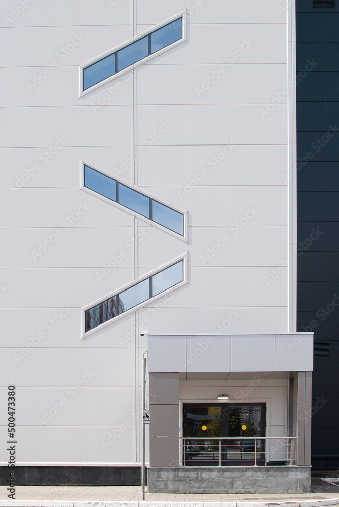 Naklejka premium a building with small windows and a glass entrance inside the building with light walls