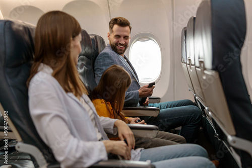 Happy family traveling together on passenger aircraft