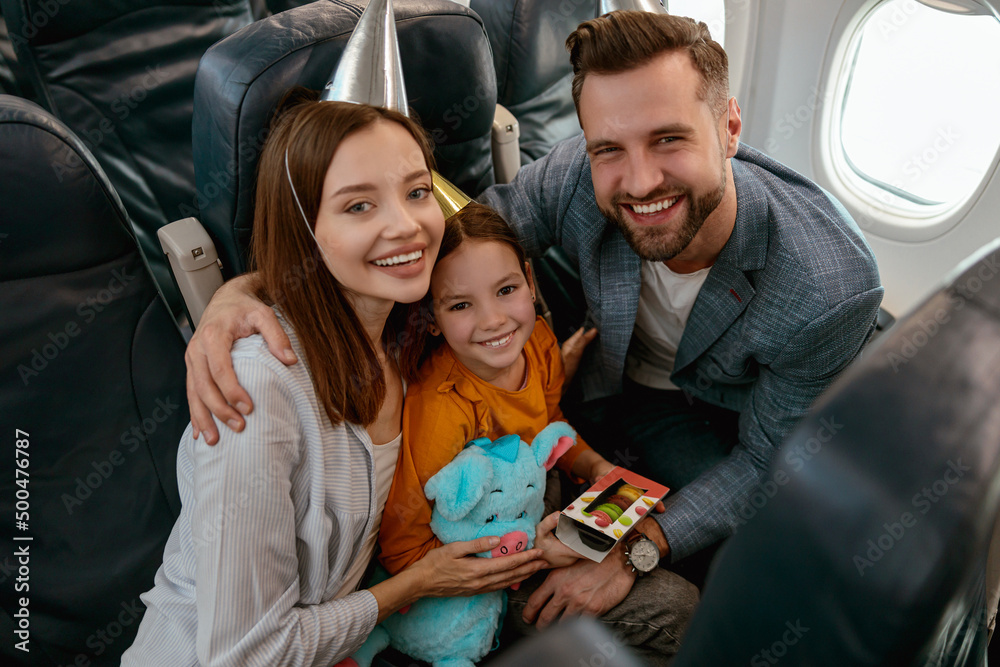 Happy family celebrating child birthday in airplane Happy family celebrating child birthday in airplane