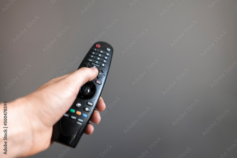 person holds the tv remote watching series at home person holds the tv remote watching series at home