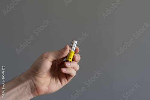 hand holding the charged electric alkaline aa battery