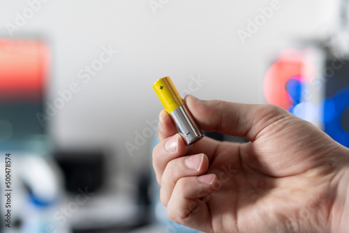 hand holding the charged electric alkaline aa battery photo