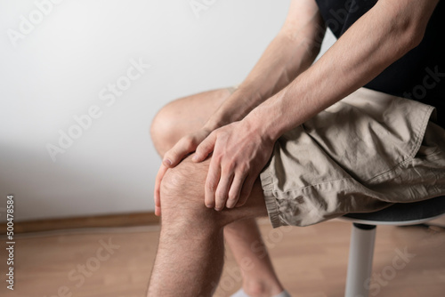 man touch his ankle, feeling pain and stress