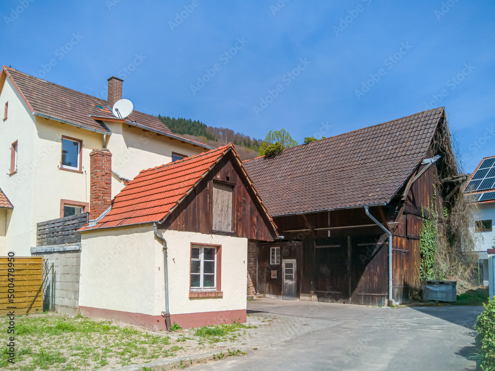 old barn buildings on the outskirts of a small german town remind of former agricultural uses