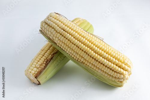Healthy and delicious whole ears of corn, raw and with straw