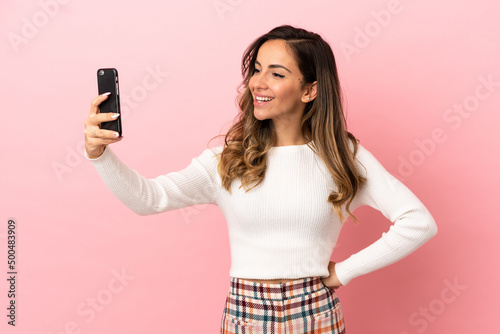 Young woman over isolated background making a selfie