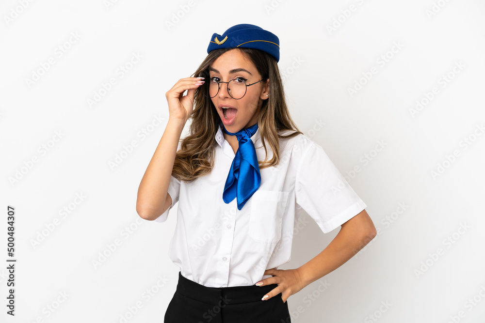 Airplane stewardess over isolated white background with glasses and surprised Airplane stewardess over isolated white background with glasses and surprised