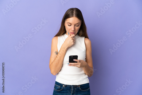 Young Lithuanian woman isolated on purple background thinking and sending a message