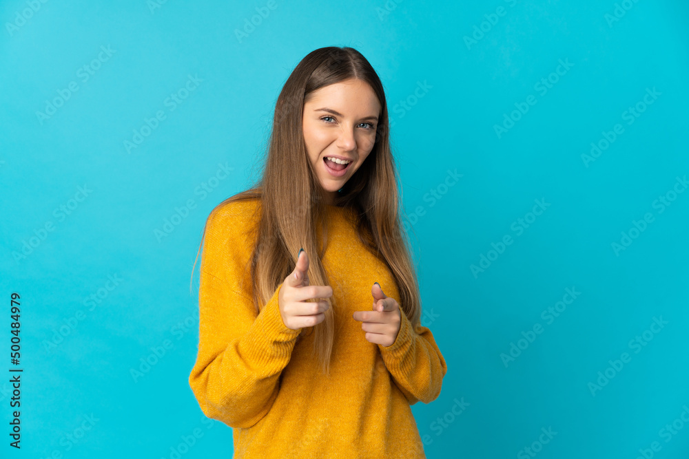 Fototapeta premium Young Lithuanian woman isolated on blue background pointing to the front and smiling