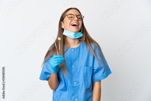 Lithuanian woman dentist holding tools over isolated background laughing
