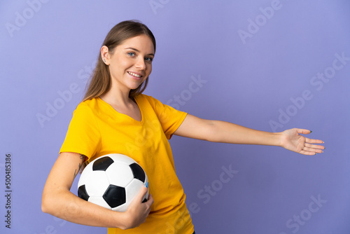 Young Lithuanian football player woman isolated on purple background extending hands to the side for inviting to come © luismolinero