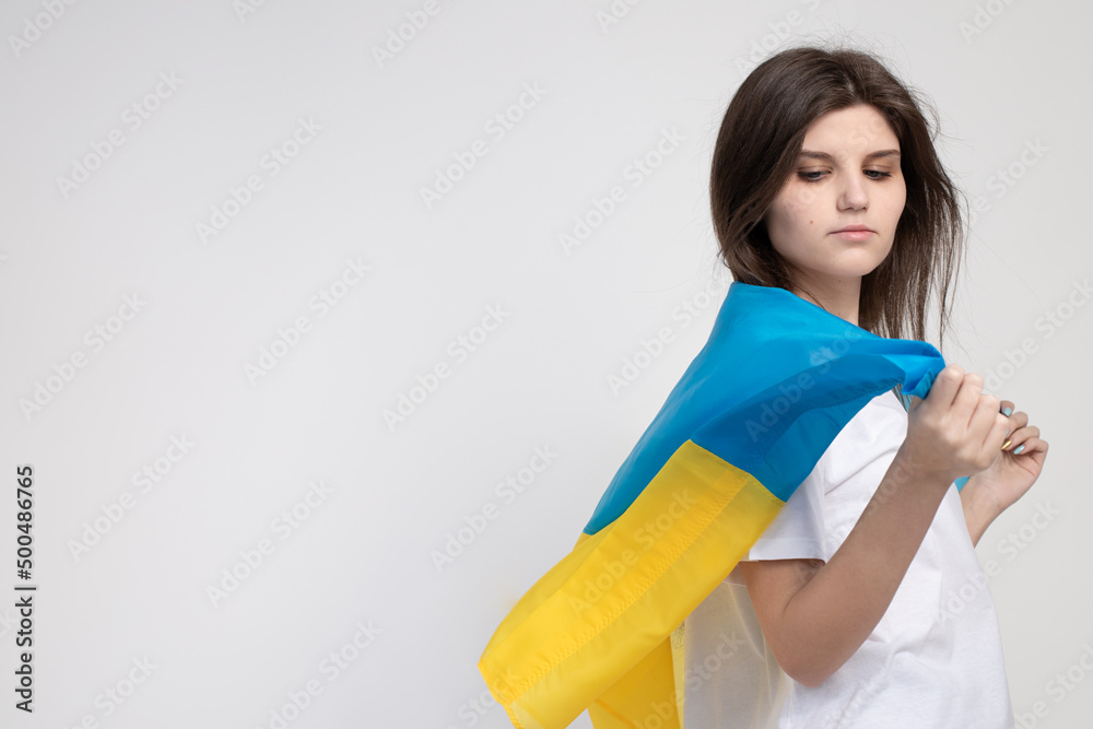 Woman holds ukrainian blue and yellow flag on white background, copy space blank. Space for text. National symbol of freedom and independence. Stop the war. Woman holds ukrainian blue and yellow flag on white background, copy space blank. Space for text. National symbol of freedom and independence. Stop the war.