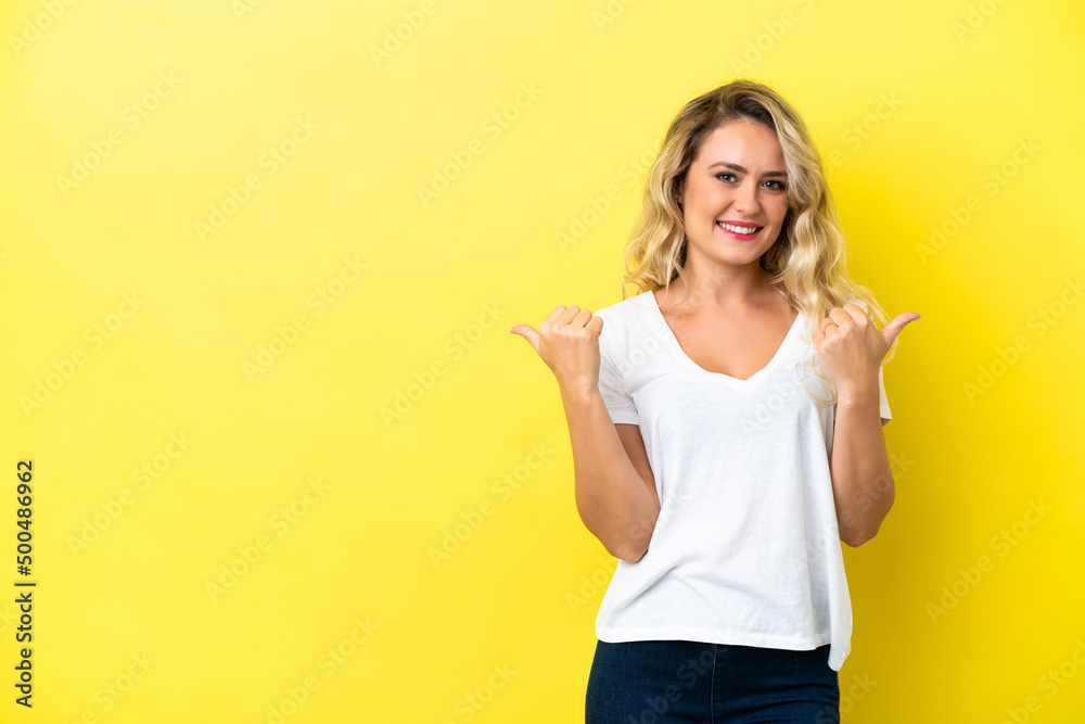 Young Brazilian woman isolated on yellow background with thumbs up gesture and smiling Young Brazilian woman isolated on yellow background with thumbs up gesture and smiling