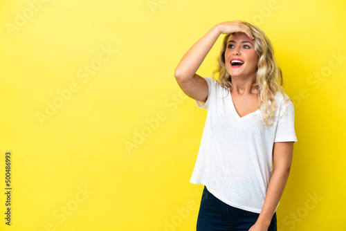 Young Brazilian woman isolated on yellow background doing surprise gesture while looking front