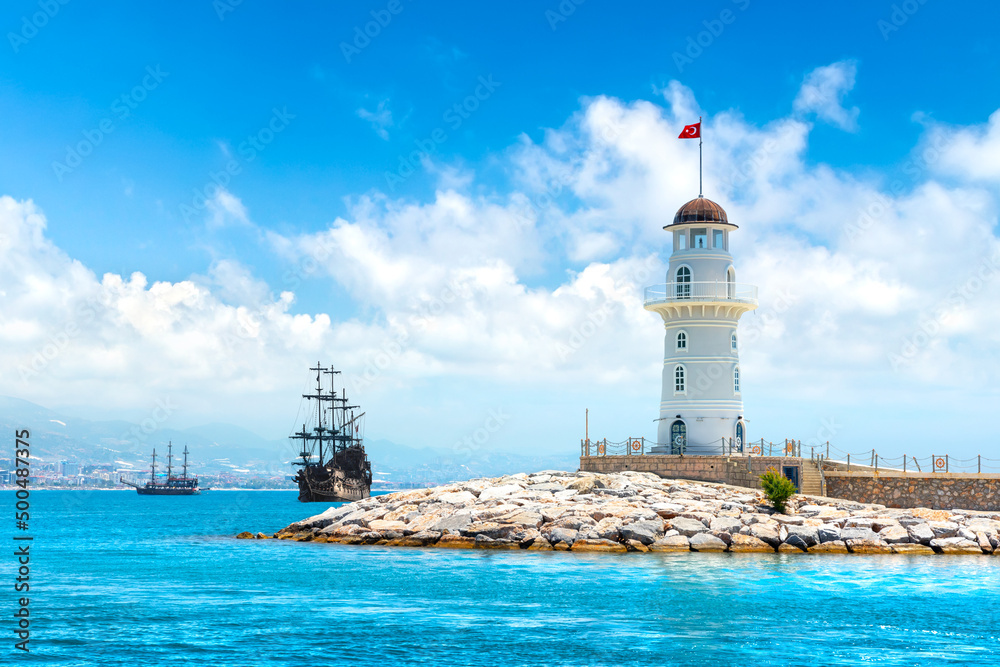 Landscape view with wooden sailing ships and Alanya port lighthouse, Alanya, Turkey
