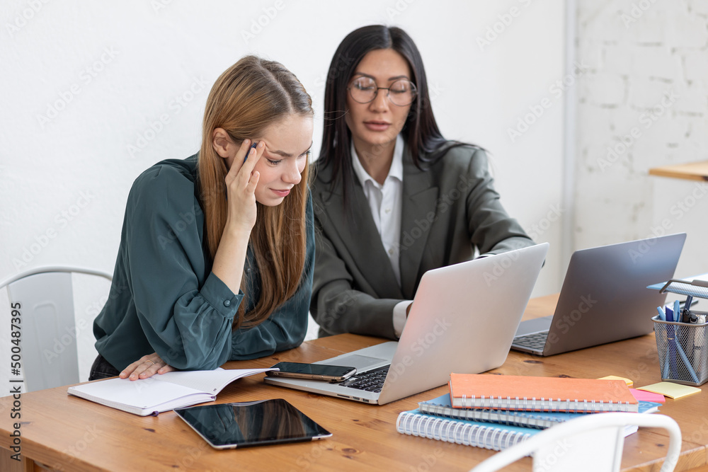 Two young women in office. Talking, discussion, team work, collaboration. Diversity, asian female. Concept of job in corporation, young professionals. Finance, marketing Two young women in office. Talking, discussion, team work, collaboration. Diversity, asian female. Concept of job in corporation, young professionals. Finance, marketing