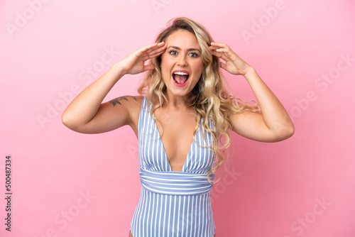Young Brazilian woman in swimsuit in summer holidays isolated on pink background with surprise expression